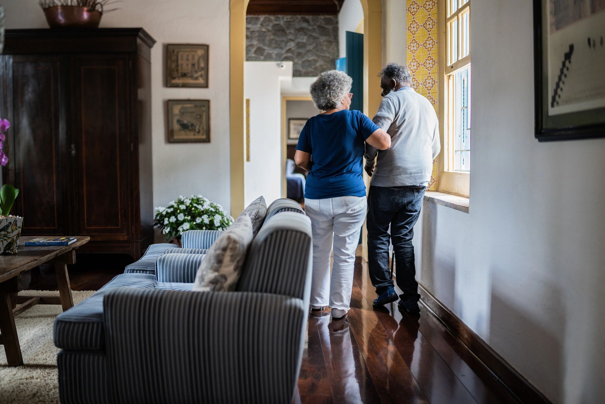 Spouse helping partner walk safely at home