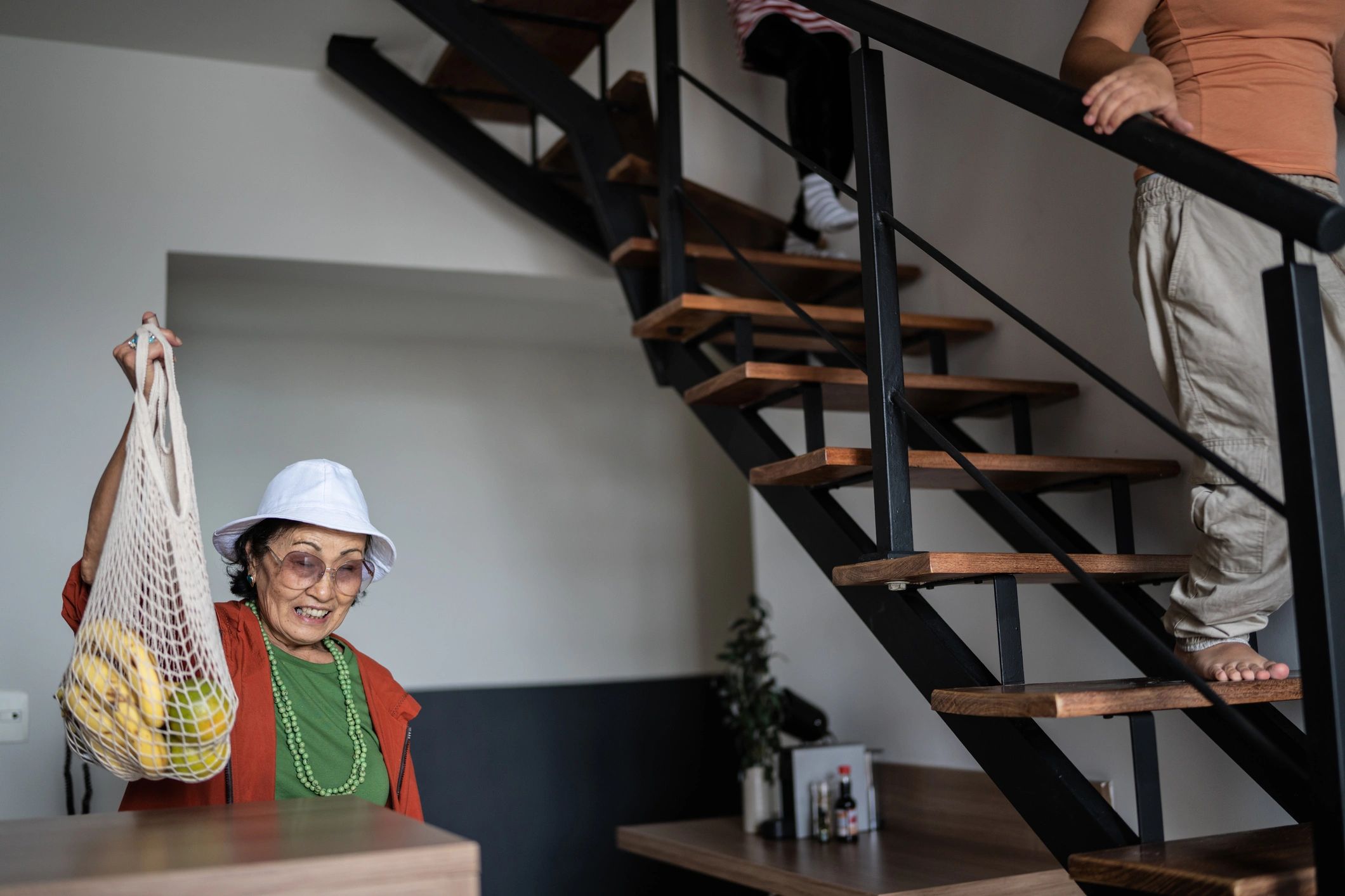 Senior using a handrail while entering a well-lit home
