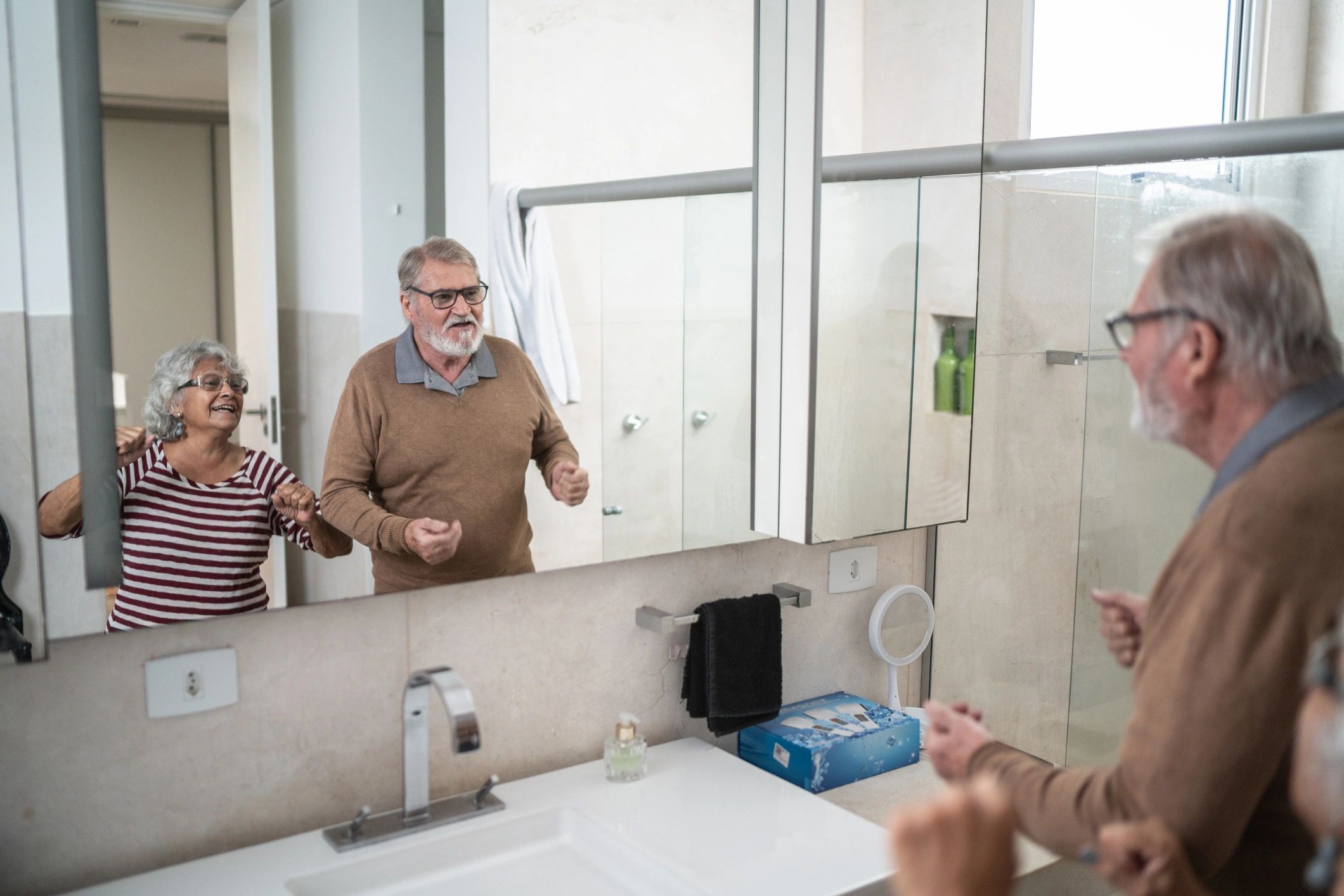 Older couple preparing in the bathroom at home