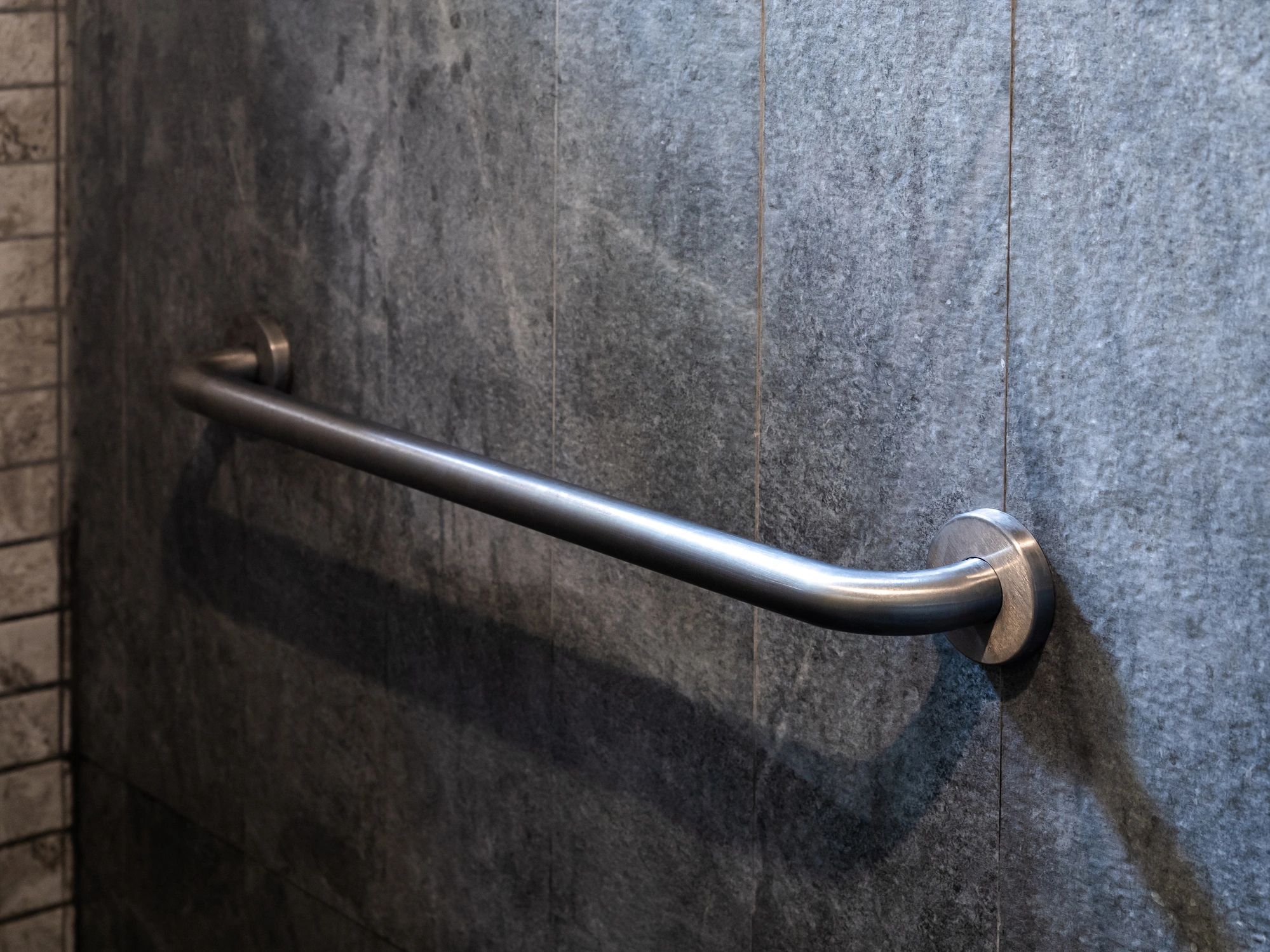 Bathroom grab bar installed on tile wall