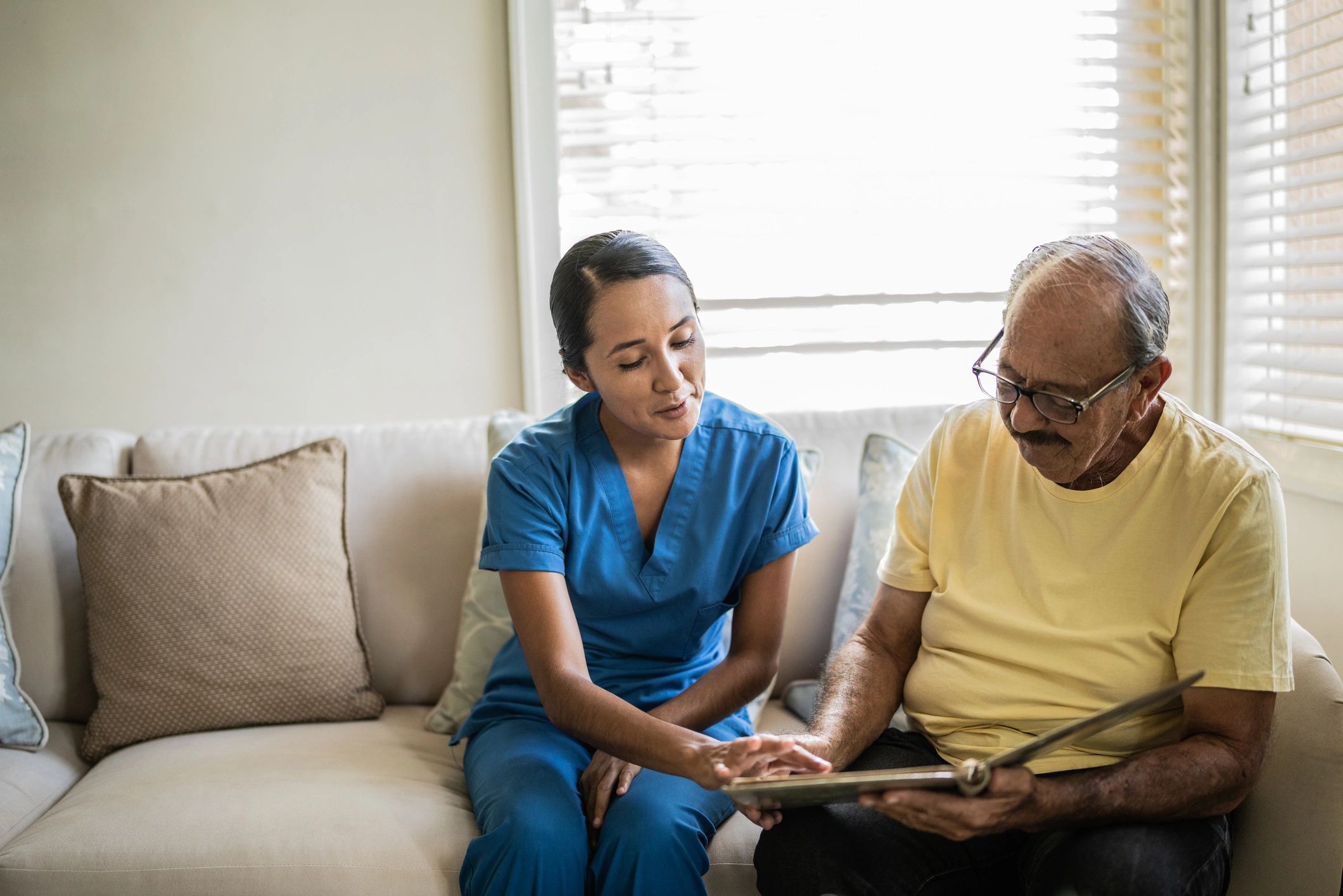 Caregiver and older adult reviewing information together at home