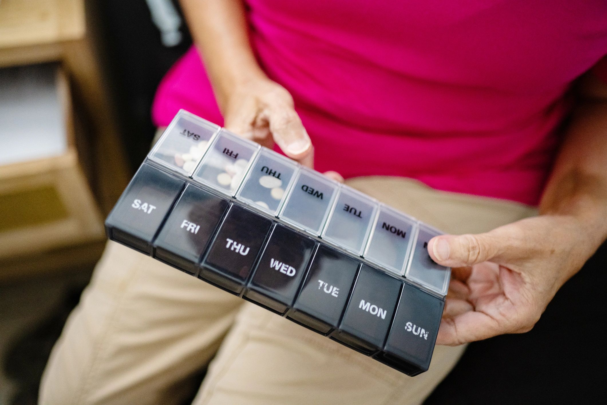 Senior holding a pill organizer