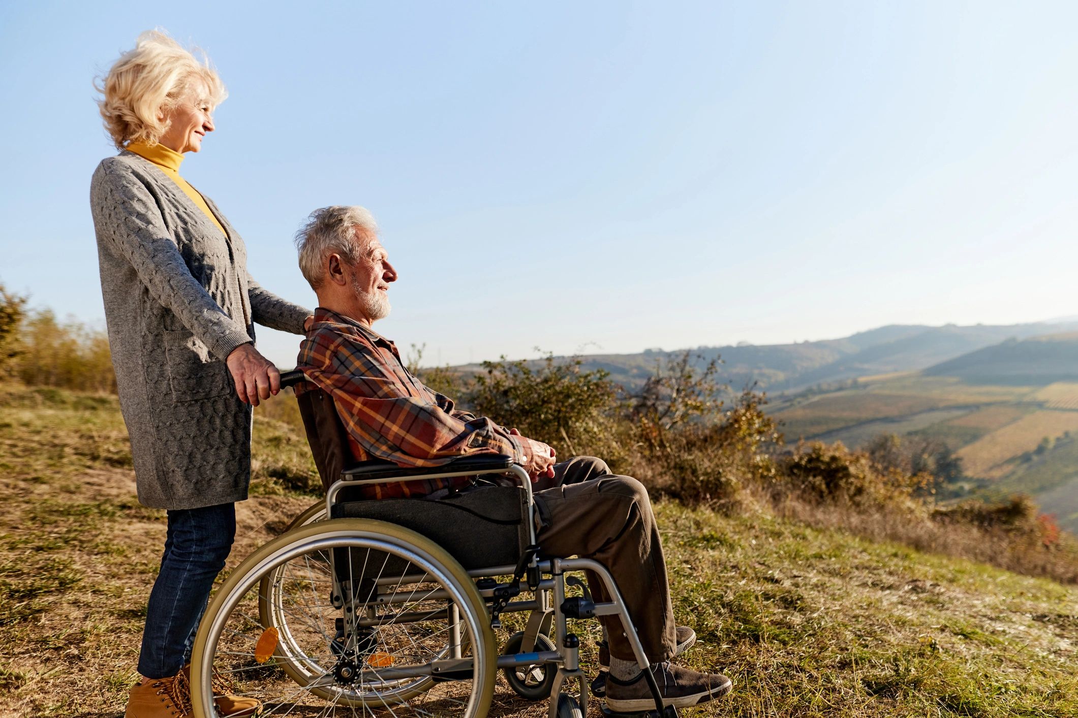 Happy disabled man and his wife on a hill in autumn day.