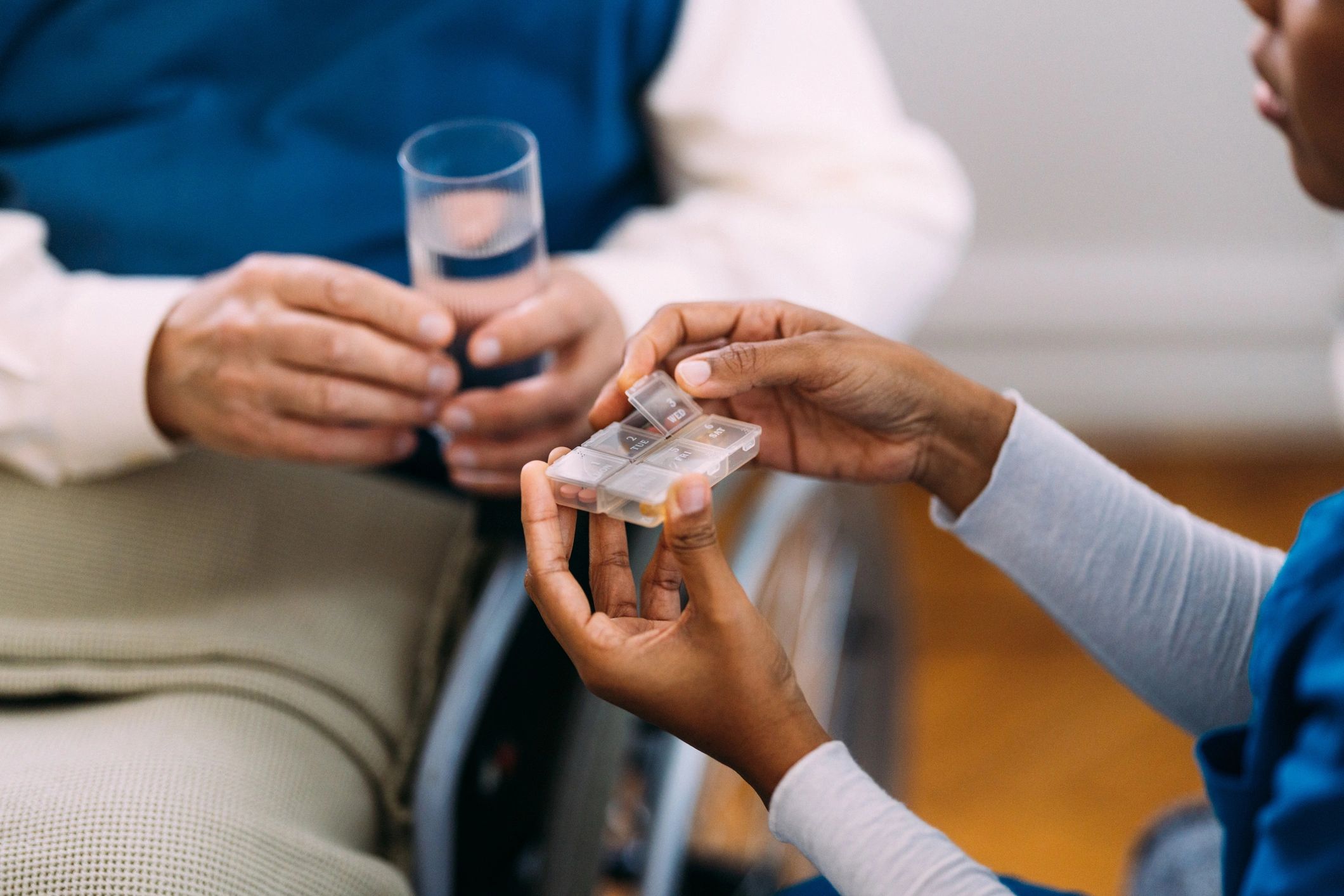 Caregiver assisting a senior with medication organizer