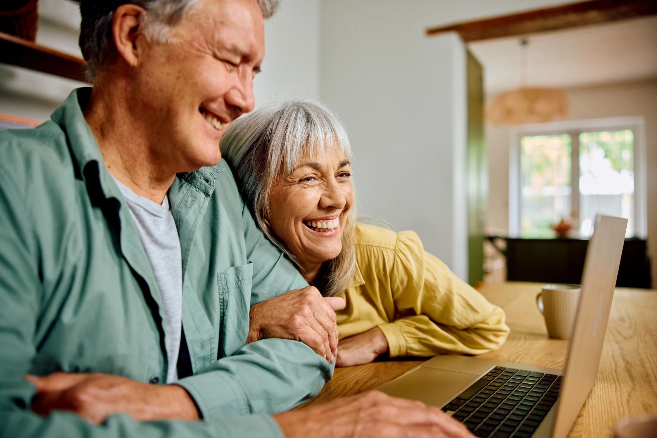 Senior couple using a laptop together at home