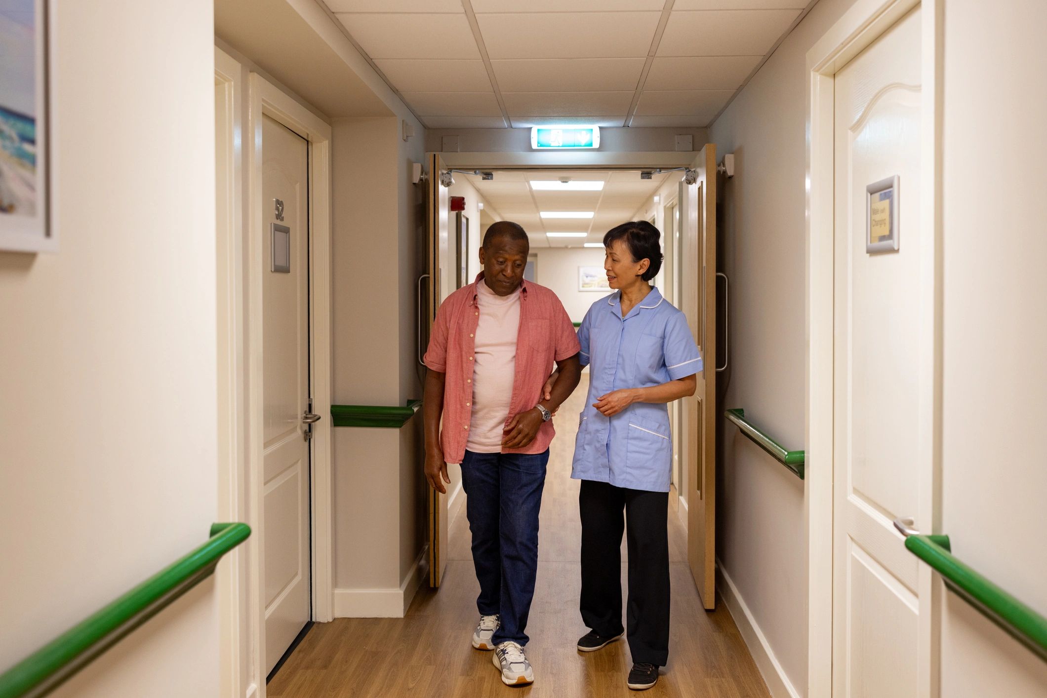 Care worker supporting an older adult while walking